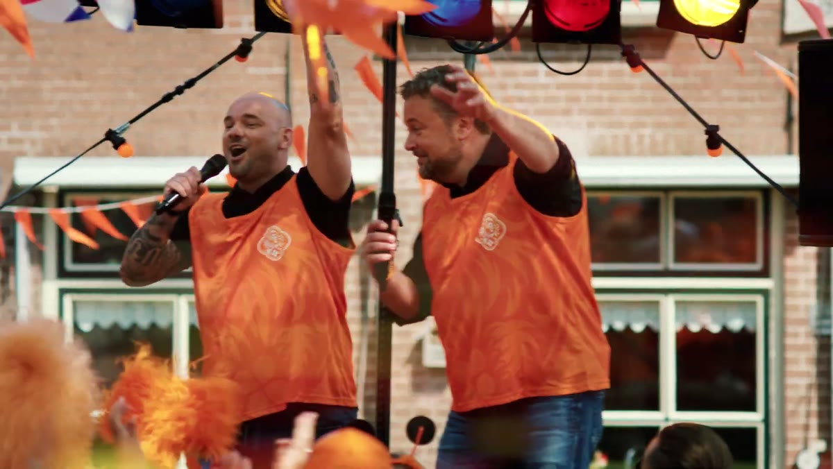 Wes & Wes sing on a stage in orange